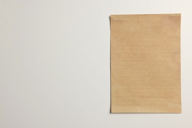 Photo of Sheet of old parchment paper on white background, top view. Space for text