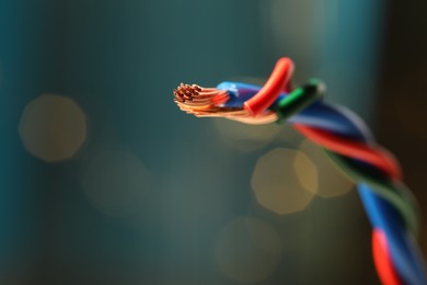 Photo of Stranded copper wires with insulation against blurred background, closeup. Space for text