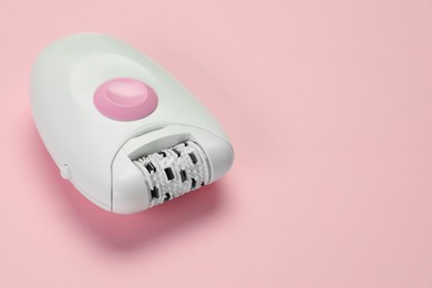 Photo of Modern epilator on pink background, closeup. Space for text