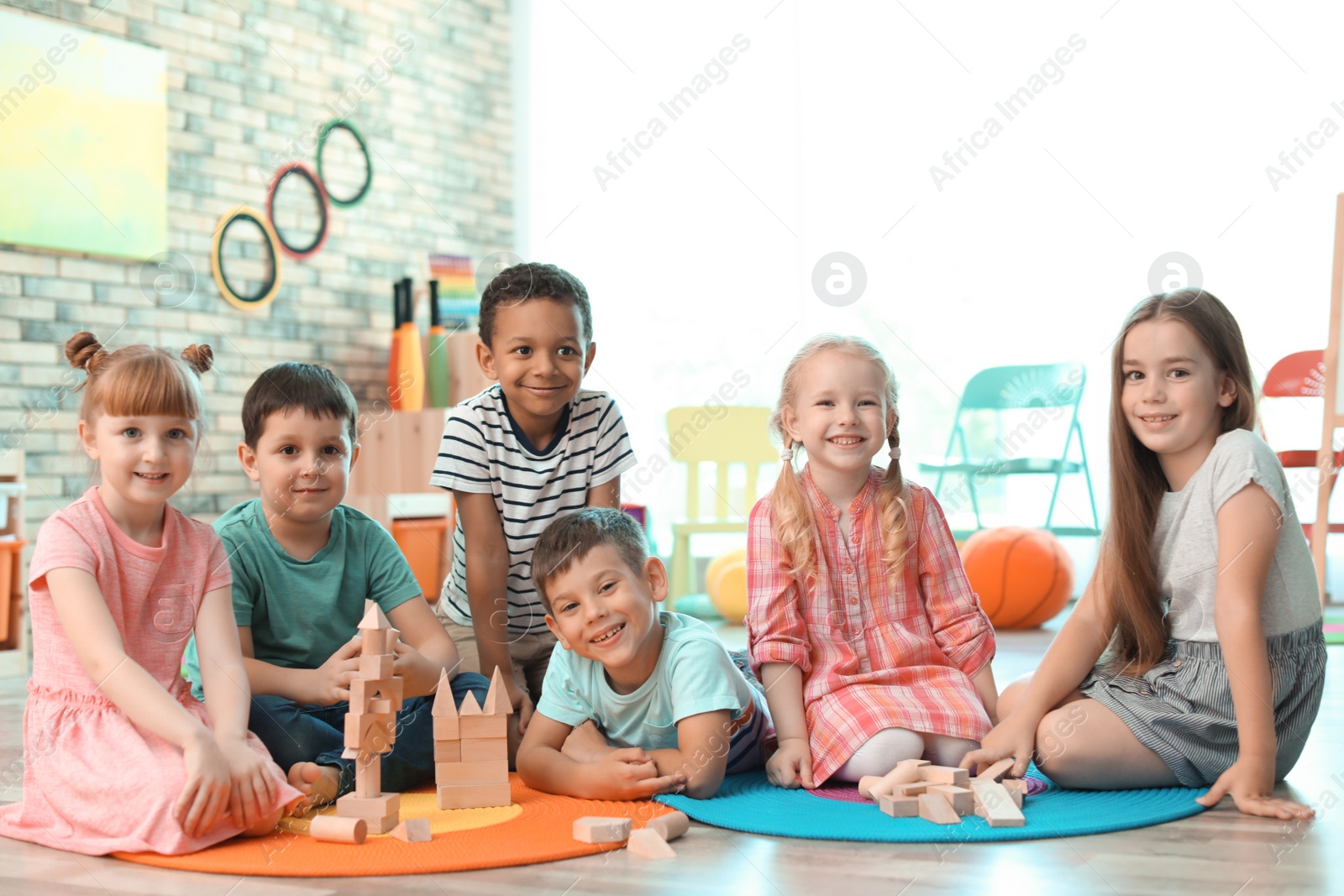 Photo of Cute little children playing with wooden blocks indoors