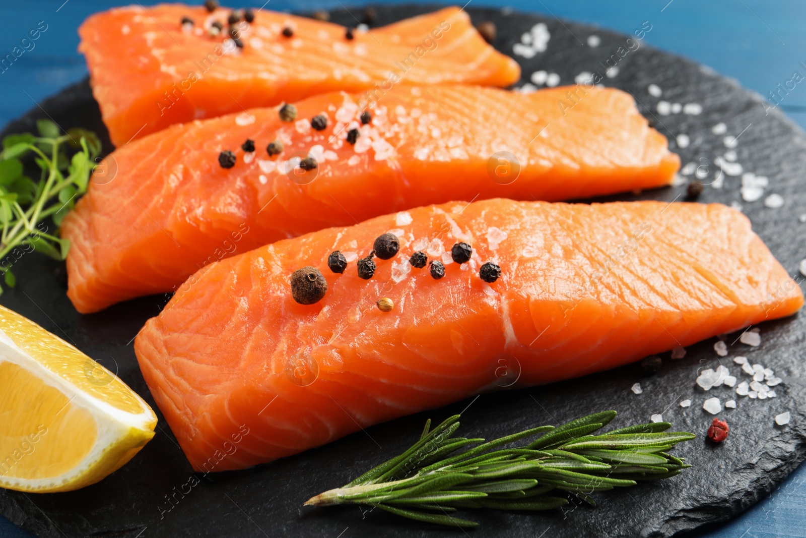 Photo of Fresh raw salmon and ingredients for marinade on slate board, closeup