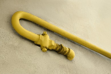 Yellow gas pipe on old wall outdoors, low angle view