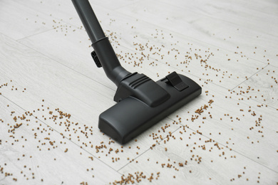Removing groats from wooden floor with vacuum cleaner at home