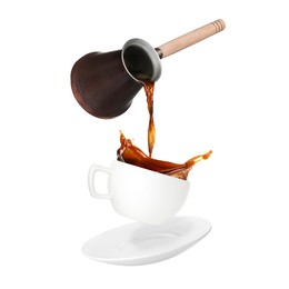 Pouring freshly brewed aromatic coffee from turkish pot into cup. Objects in air on white background