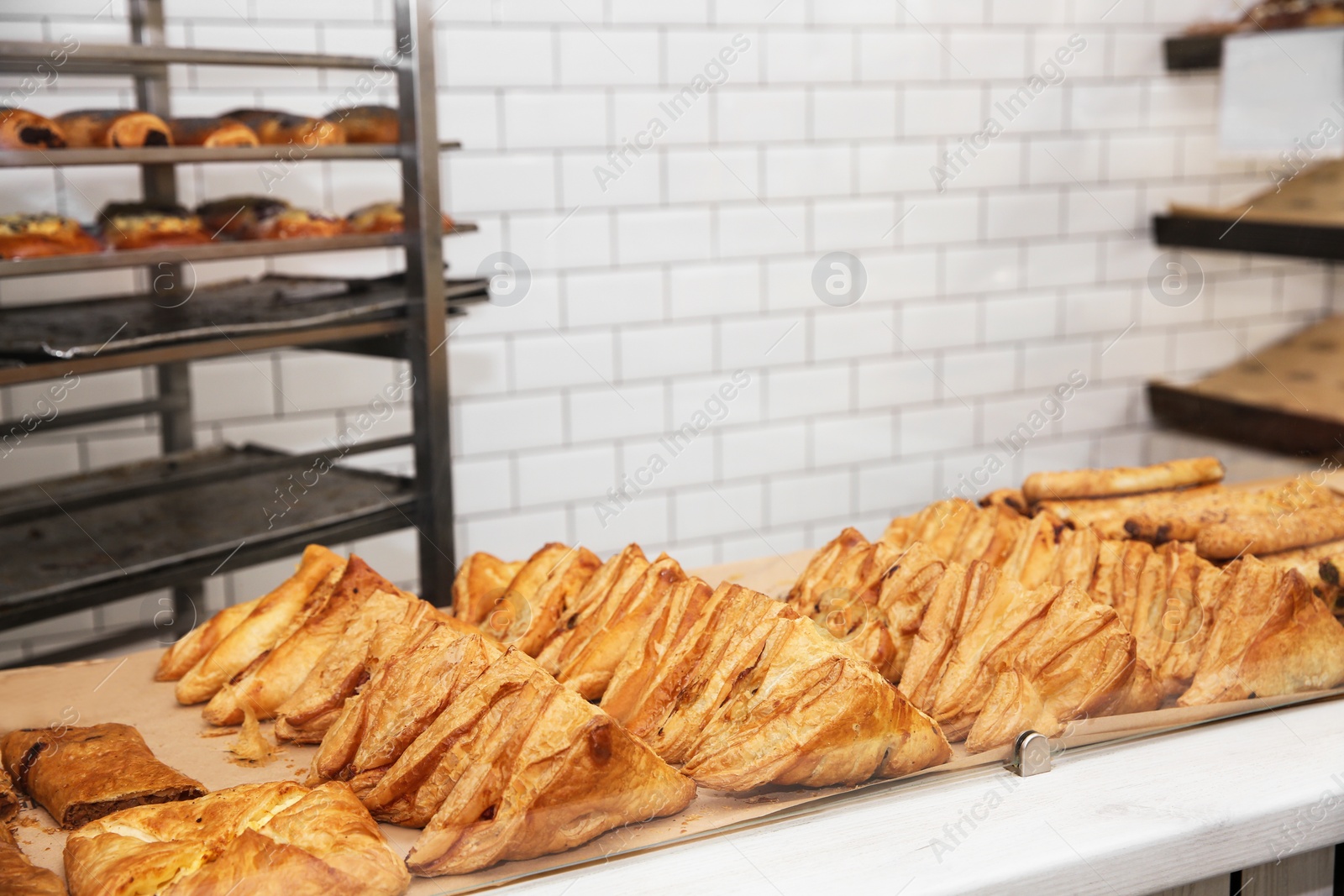 Photo of Fresh pastries on counter in bakery store. Space for text