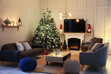 Cozy living room interior with beautiful Christmas tree near fireplace