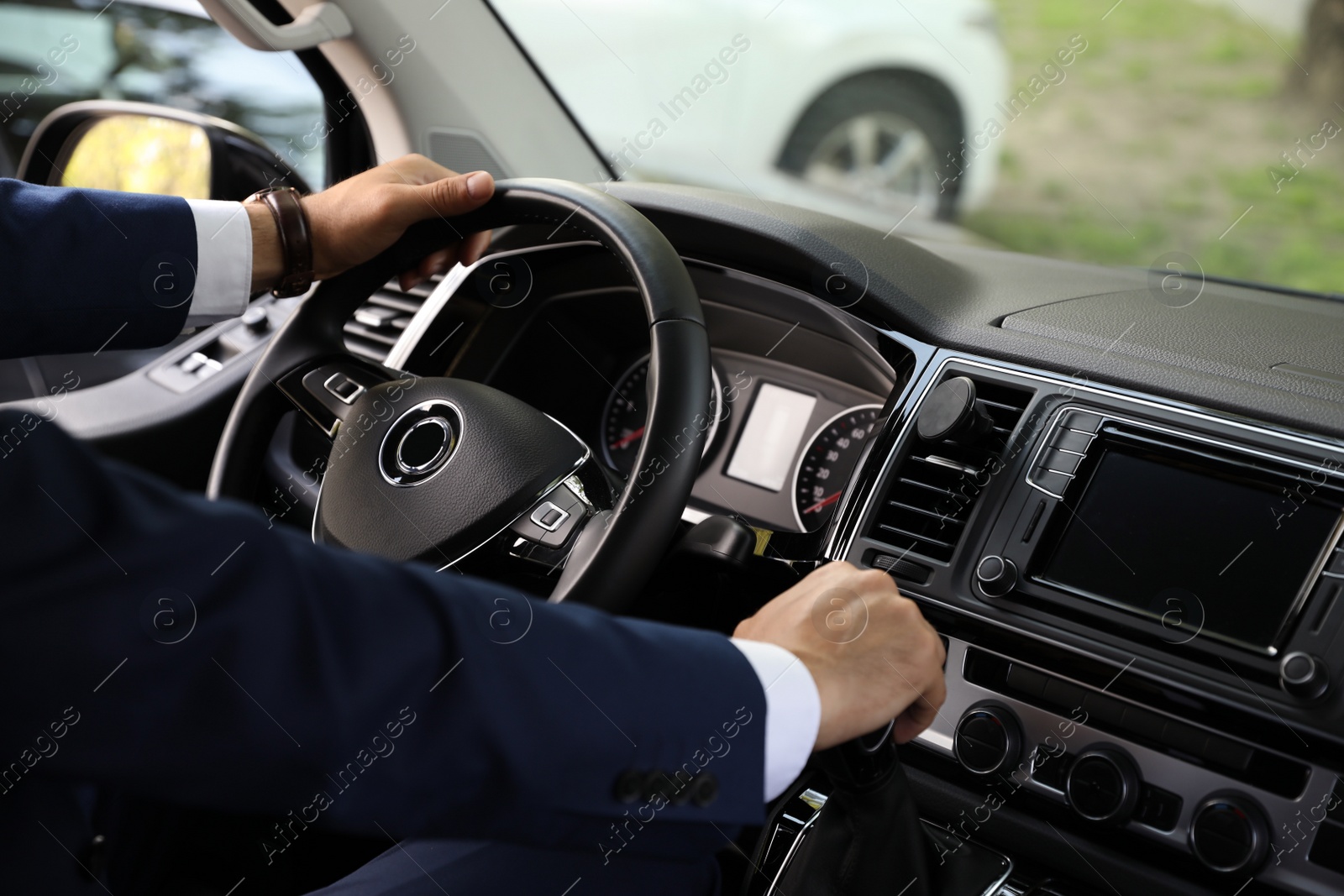 Photo of Man driving his car, closeup view of hands on steering wheel