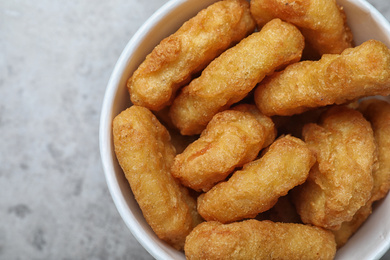 Photo of Bucket with tasty chicken nuggets on grey table, top view