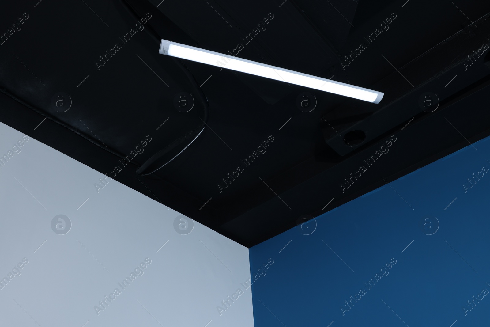 Photo of Room corner and black ceiling with modern light