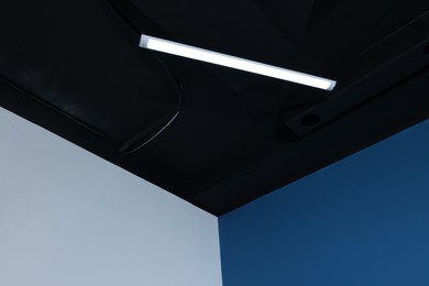 Room corner and black ceiling with modern light