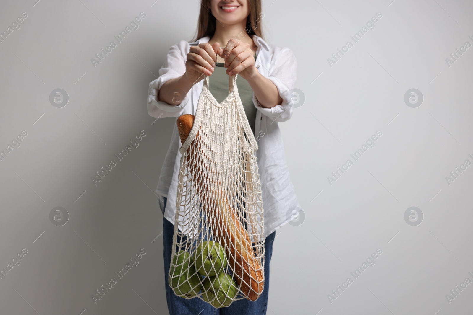 Photo of Woman with eco bag full of products on white background