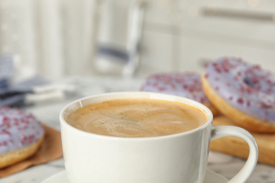 Photo of Cup of delicious coffee and pastries, closeup