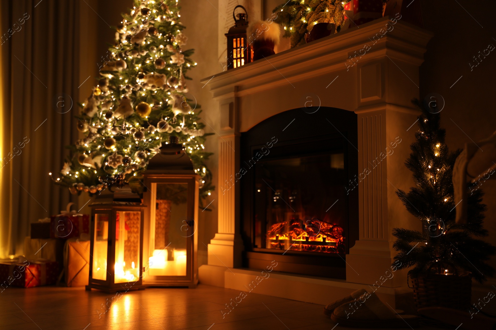 Photo of Beautiful fireplace, Christmas tree and other decorations in living room at night. Interior design