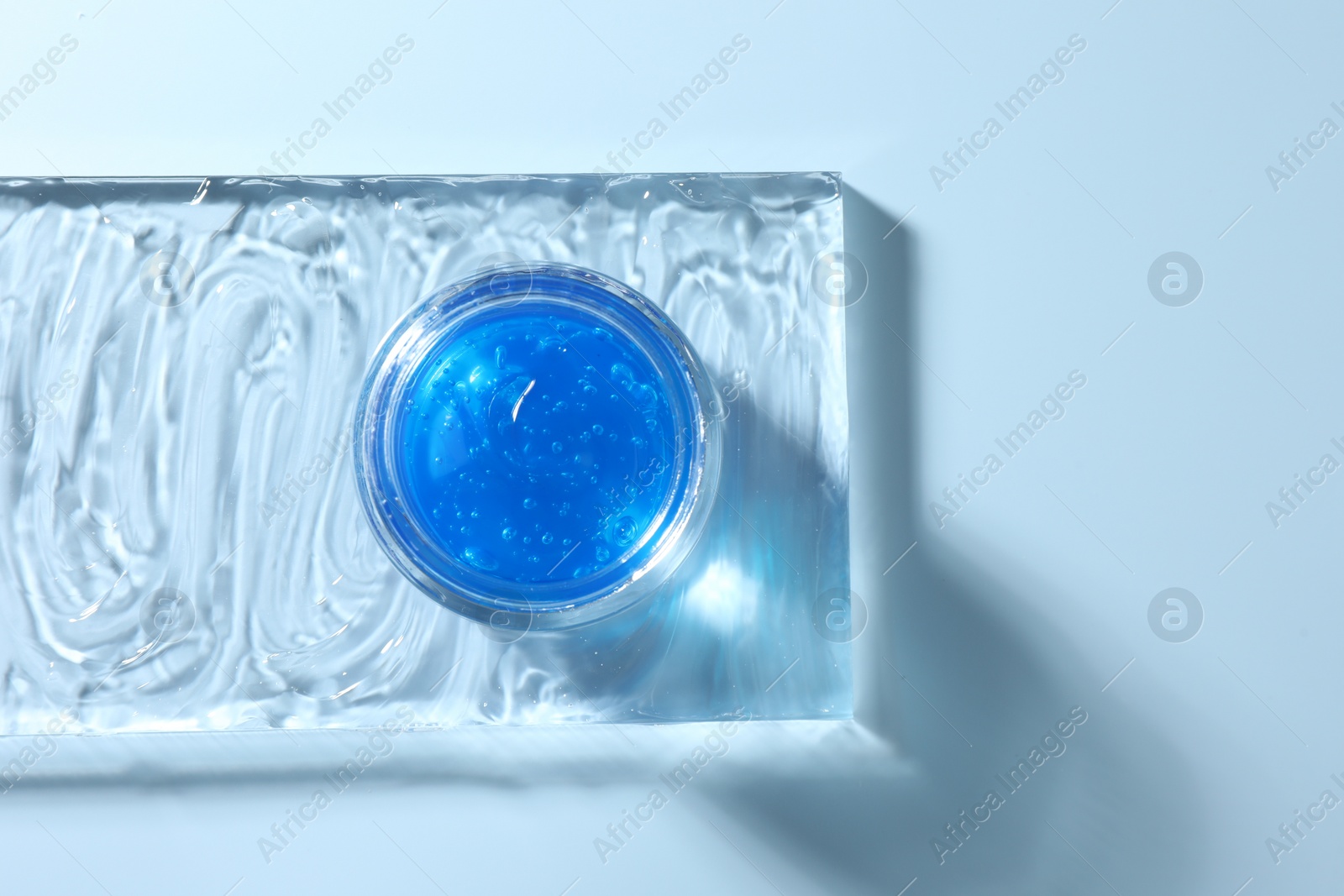 Photo of Jar of cosmetic product on light blue background, top view. Space for text