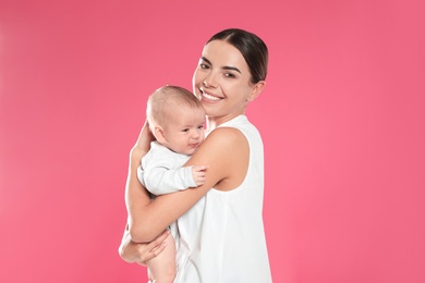 Portrait of happy mother with her baby on color background