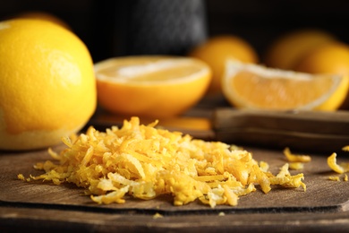 Lemon zest and fresh fruits on wooden board, closeup