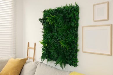 Photo of Green artificial plant panel on light wall in room