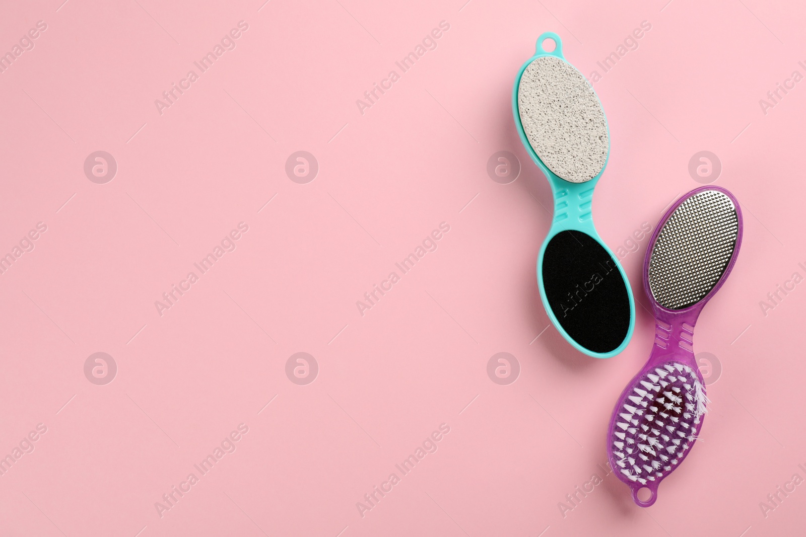 Photo of Pedicure tools with pumice stones on pink background, flat lay. Space for text