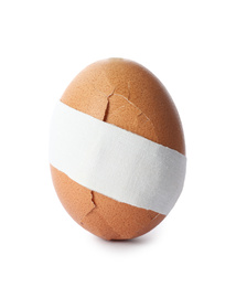 Photo of Cracked egg with sticking plaster isolated on white