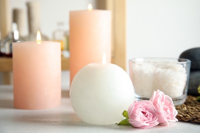 Photo of Beautiful spa composition with candles and flowers on wooden table