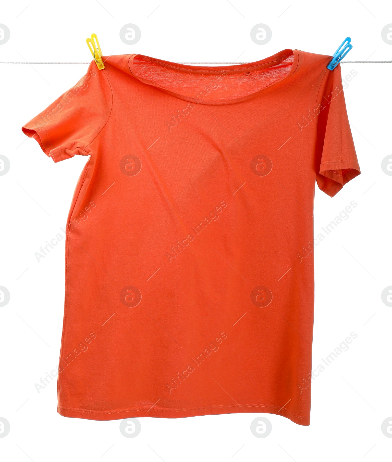 Photo of One orange t-shirt drying on washing line isolated on white