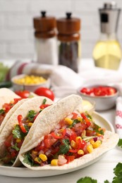 Photo of Tasty tacos with vegetables on white wooden table, closeup