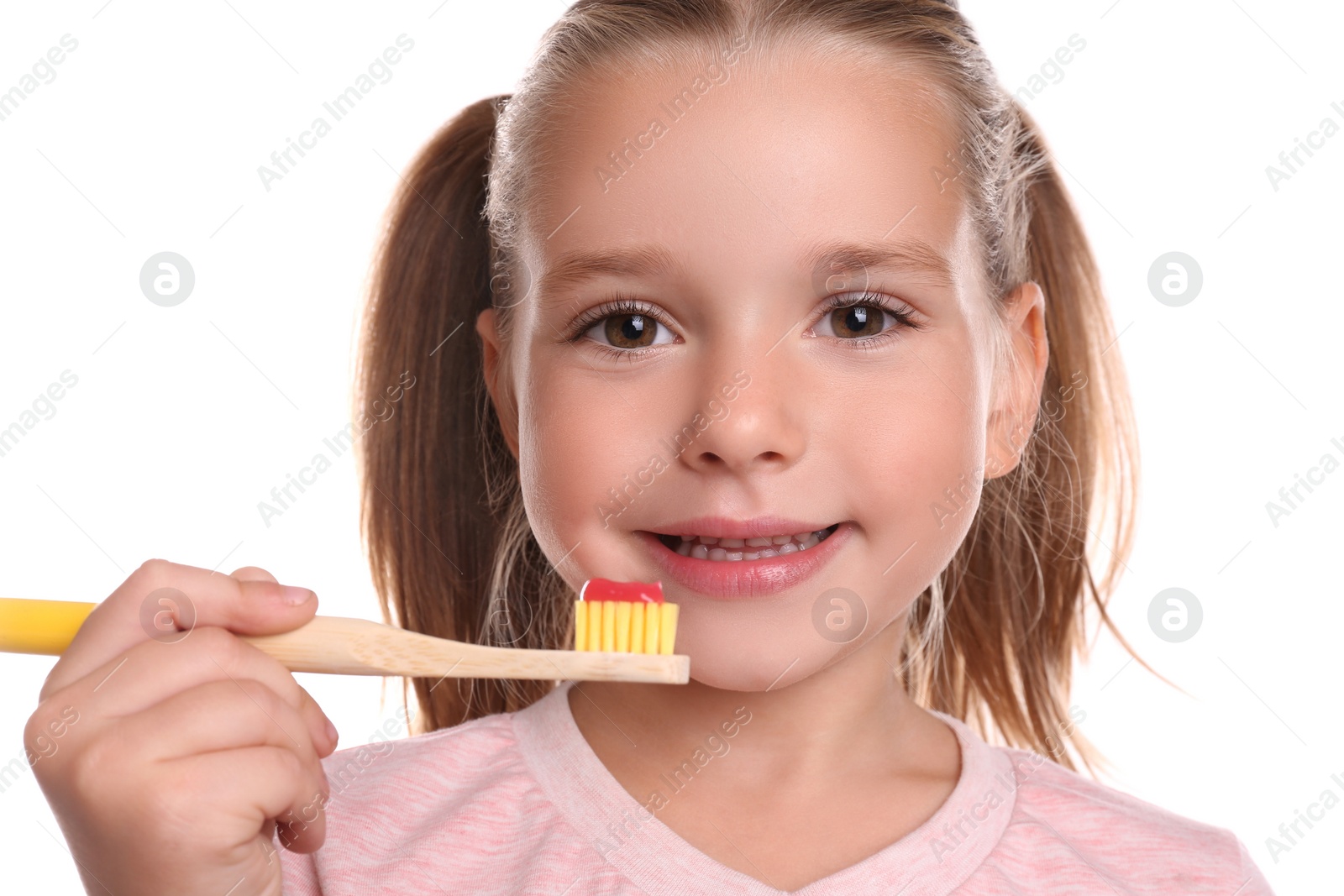 Photo of Little girl holding toothbrush with paste on white background
