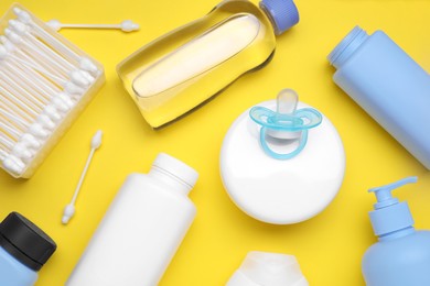 Photo of Flat lay composition with baby care products and accessories on yellow background