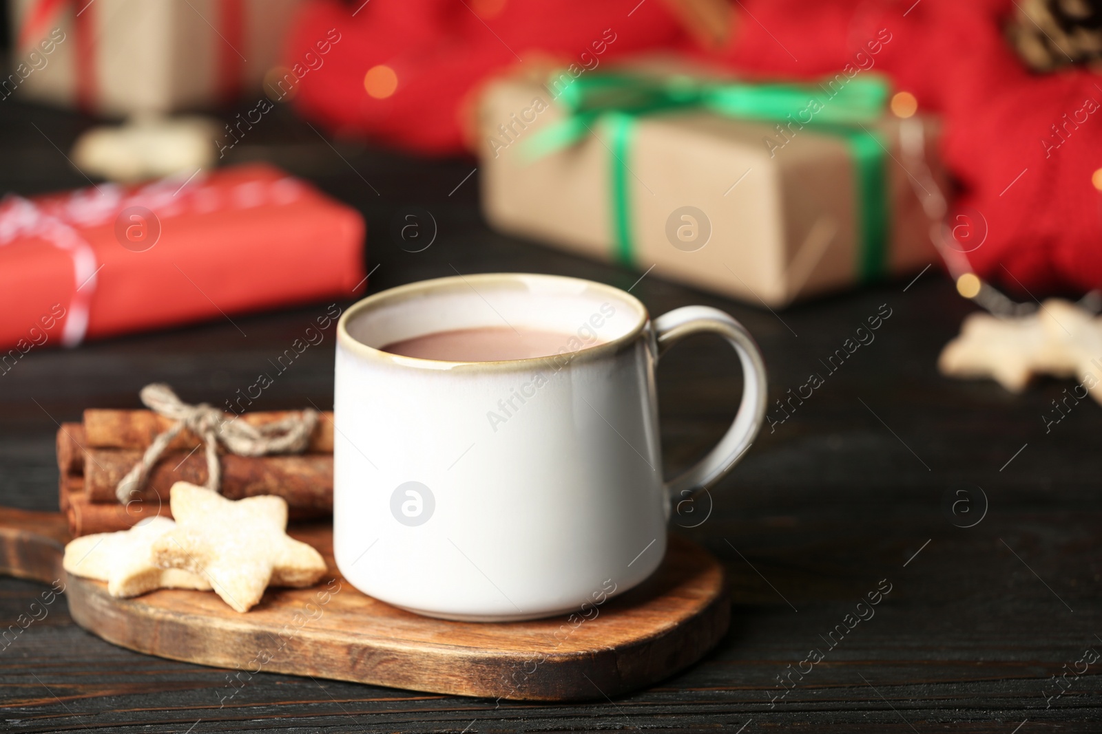 Photo of Delicious cocoa drink in white cup with cookies on black table