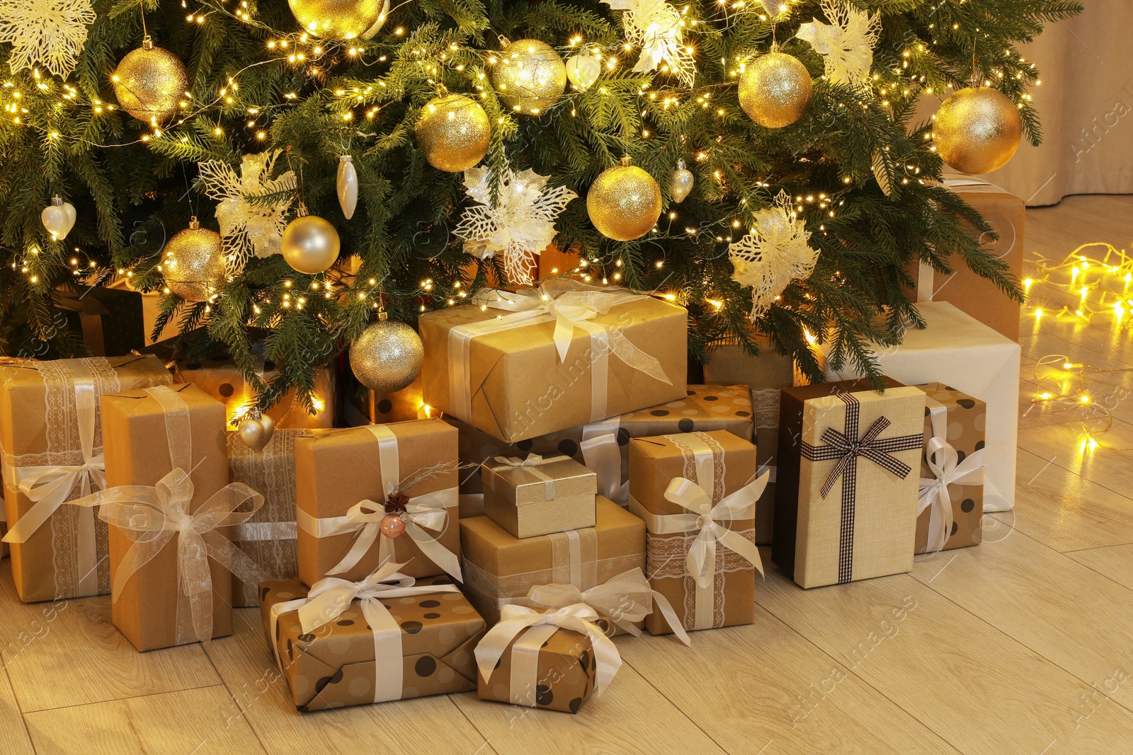 Photo of Many gift boxes under decorated Christmas tree at home