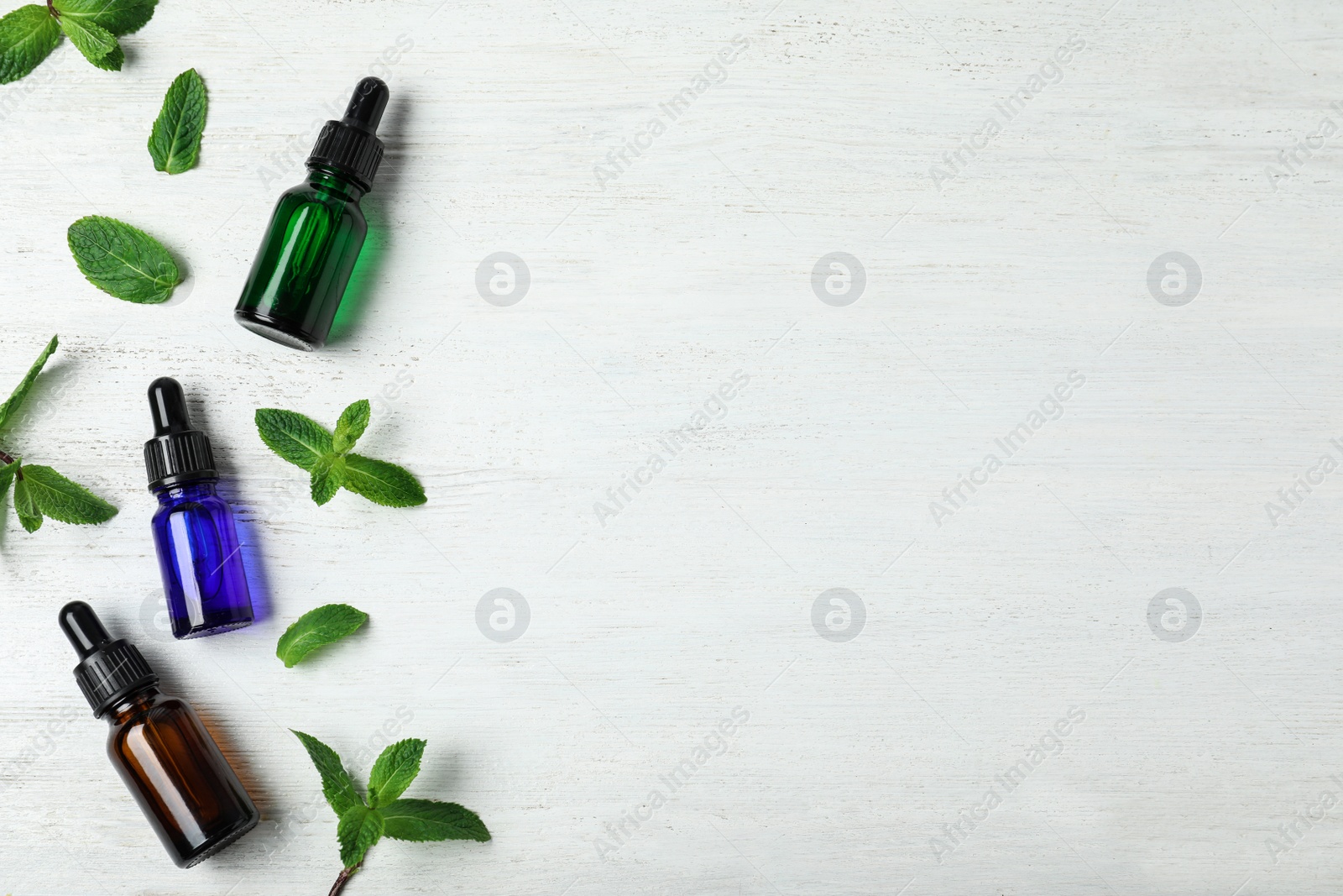 Photo of Flat lay composition with mint essential oil and space for text on white wooden background