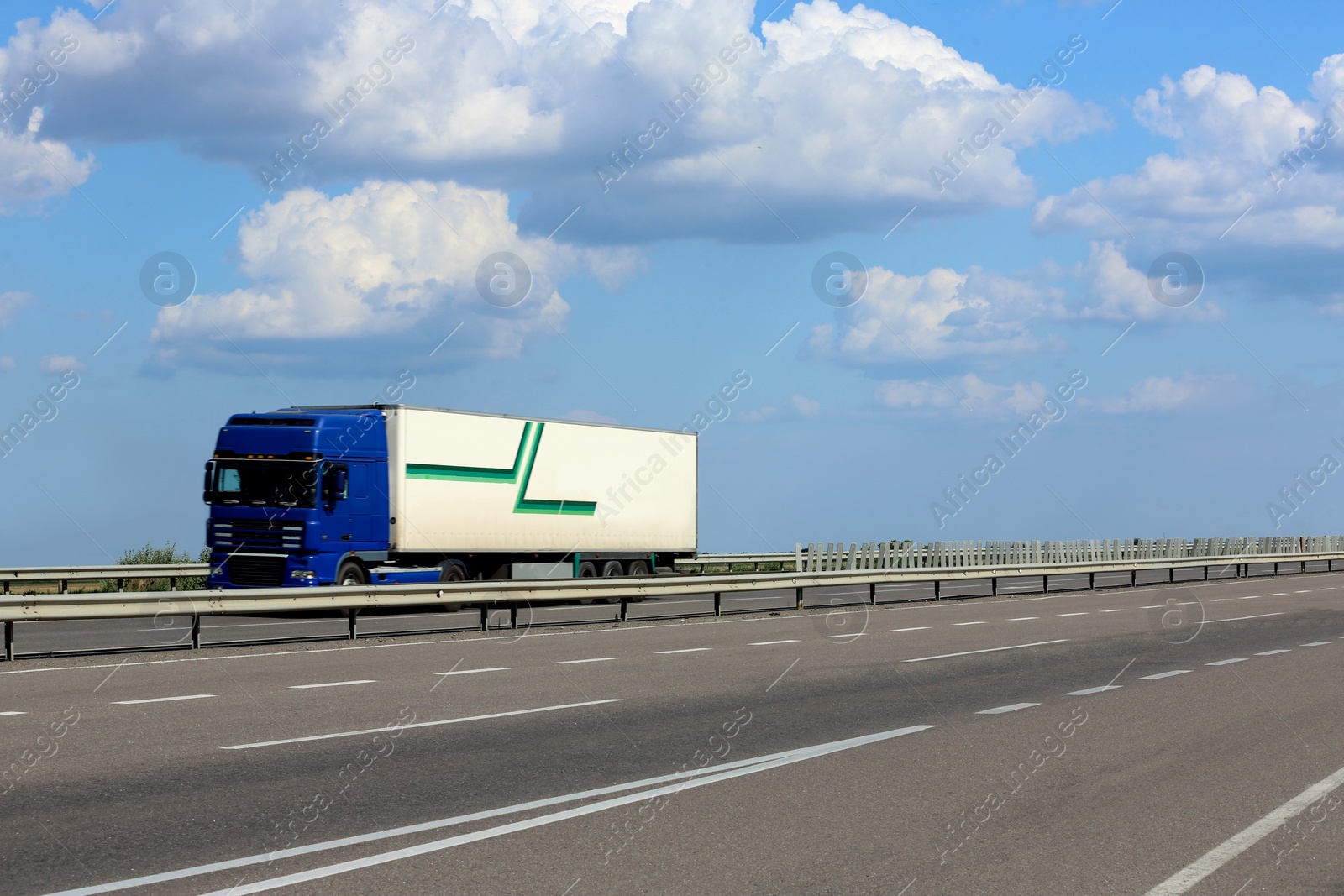 Photo of View of truck on asphalt road under blue sky