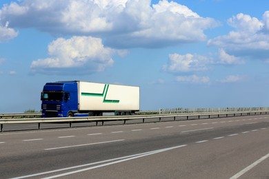 View of truck on asphalt road under blue sky