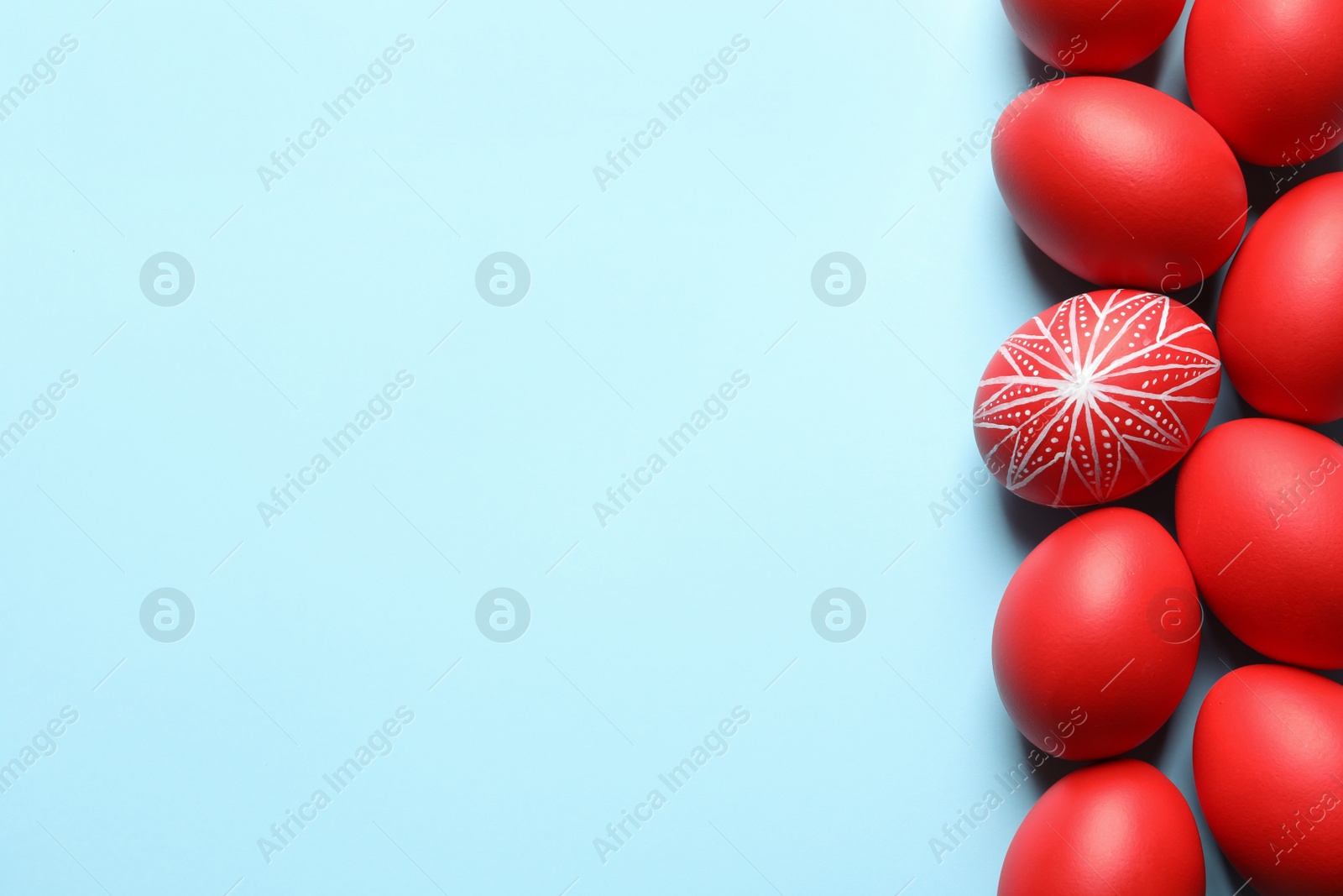 Photo of Flat lay composition of painted red Easter eggs on color background, space for text