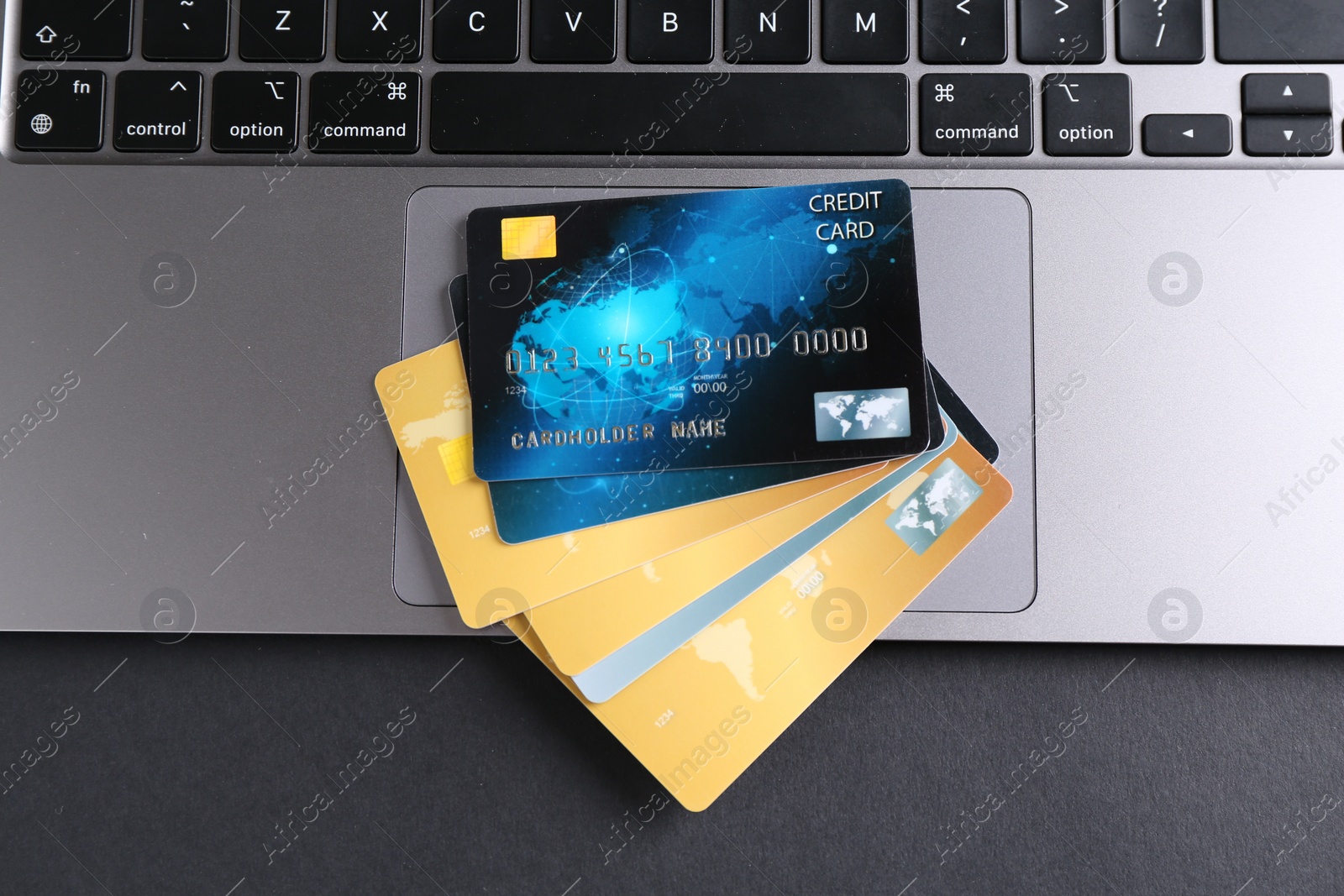 Photo of Laptop with credit cards on grey table, flat lay