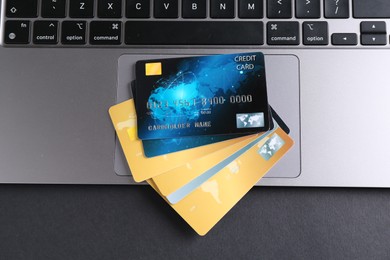 Laptop with credit cards on grey table, flat lay