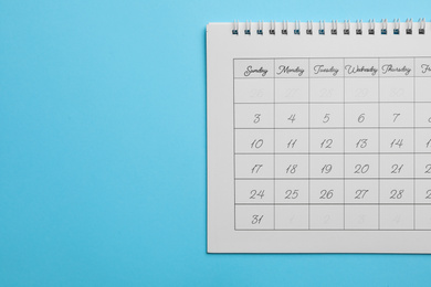Photo of Paper calendar on light blue background, top view. Space for text