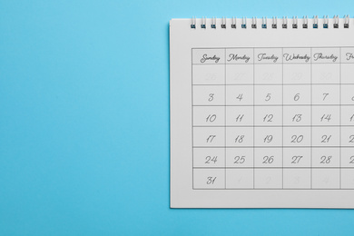 Paper calendar on light blue background, top view. Space for text