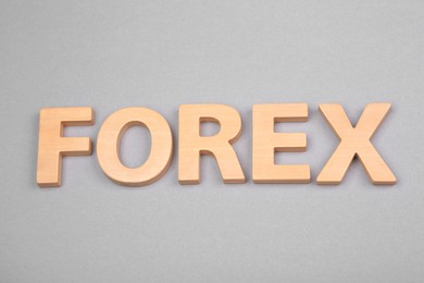 Photo of Word Forex with wooden letters on grey background, above view