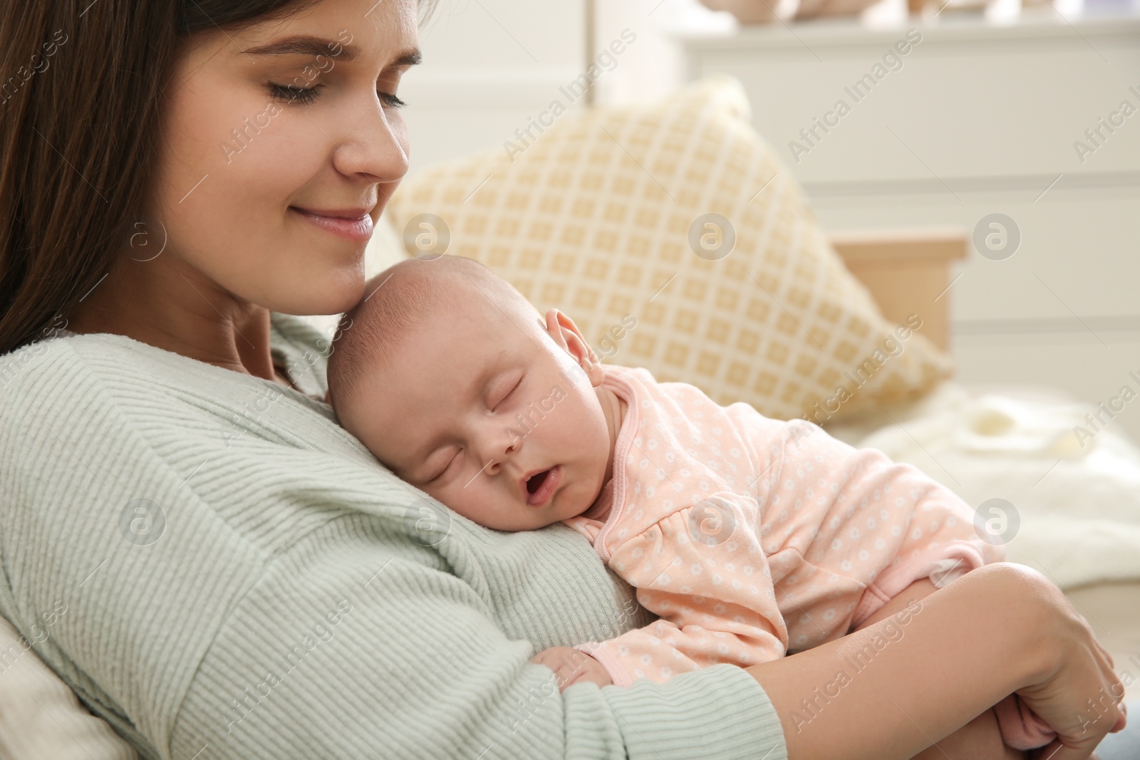 Photo of Mother holding her sleeping baby at home