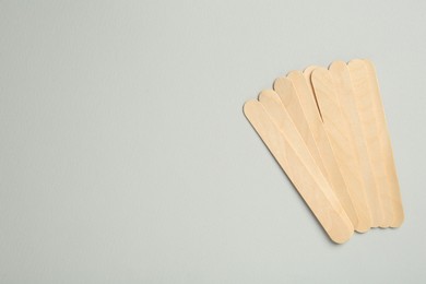 Pile of spatulas on grey background, flat lay. Space for text