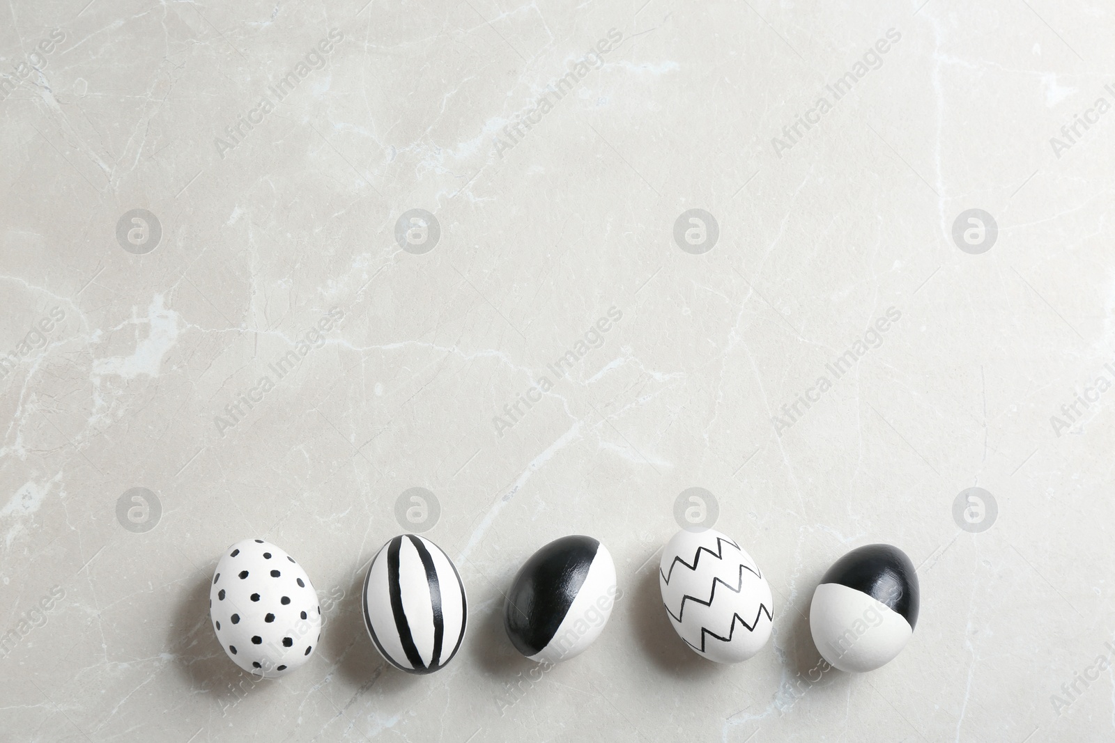 Photo of Painted Easter eggs on grey background, flat lay with space for text