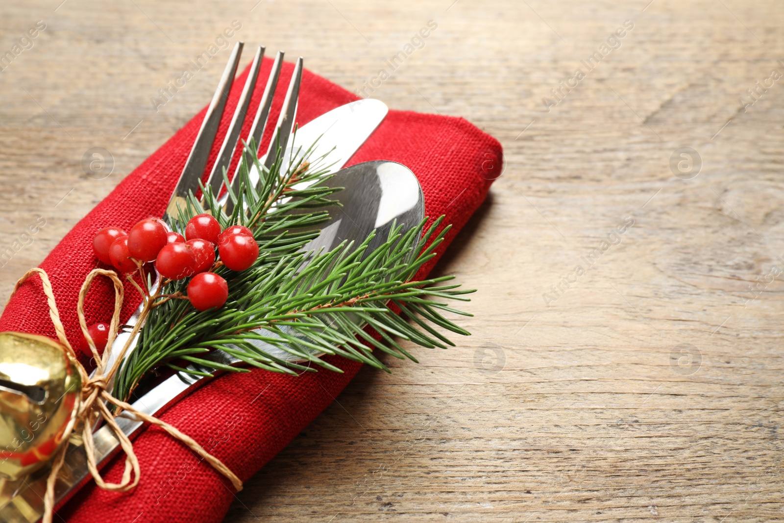 Photo of Cutlery set for festive table on wooden background, closeup. Christmas celebration