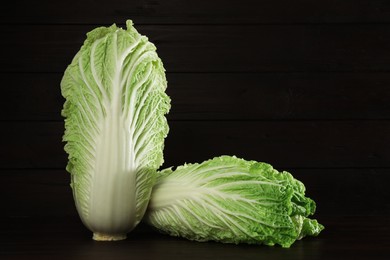 Photo of Fresh ripe Chinese cabbages on table against wooden background. Space for text