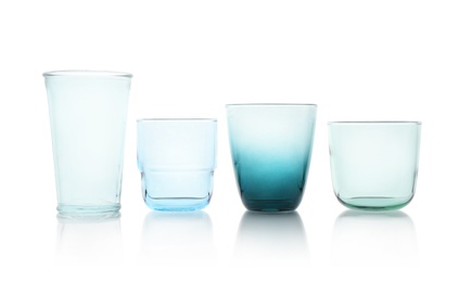 Photo of Set of colorful empty glasses on white background