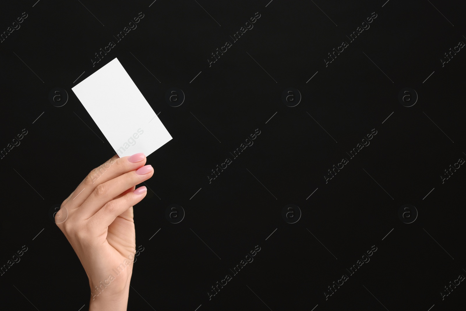 Photo of Woman holding blank business card on black background, closeup. Space for text