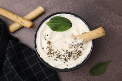 Delicious cream cheese with grissini stick and spices on grey table, flat lay