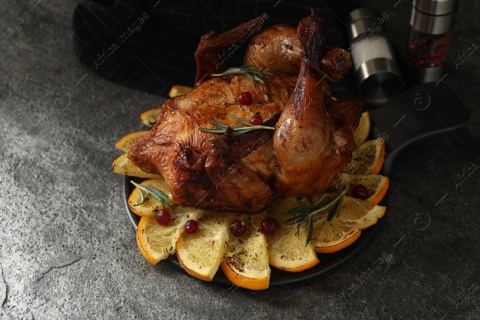 Photo of Baked chicken with orange slices on grey table