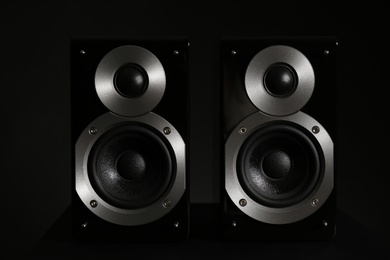 Photo of Modern powerful audio speakers on black background