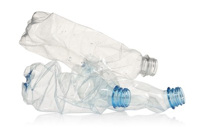 Photo of Crumpled disposable plastic bottles isolated on white